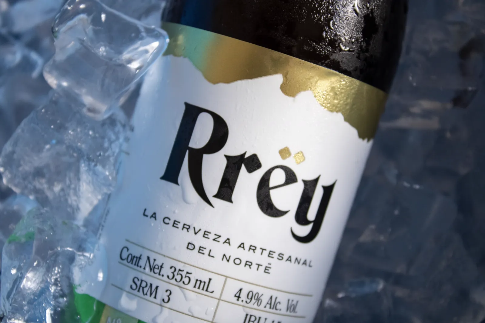 Botella de cerveza Rrëy entre hielo
